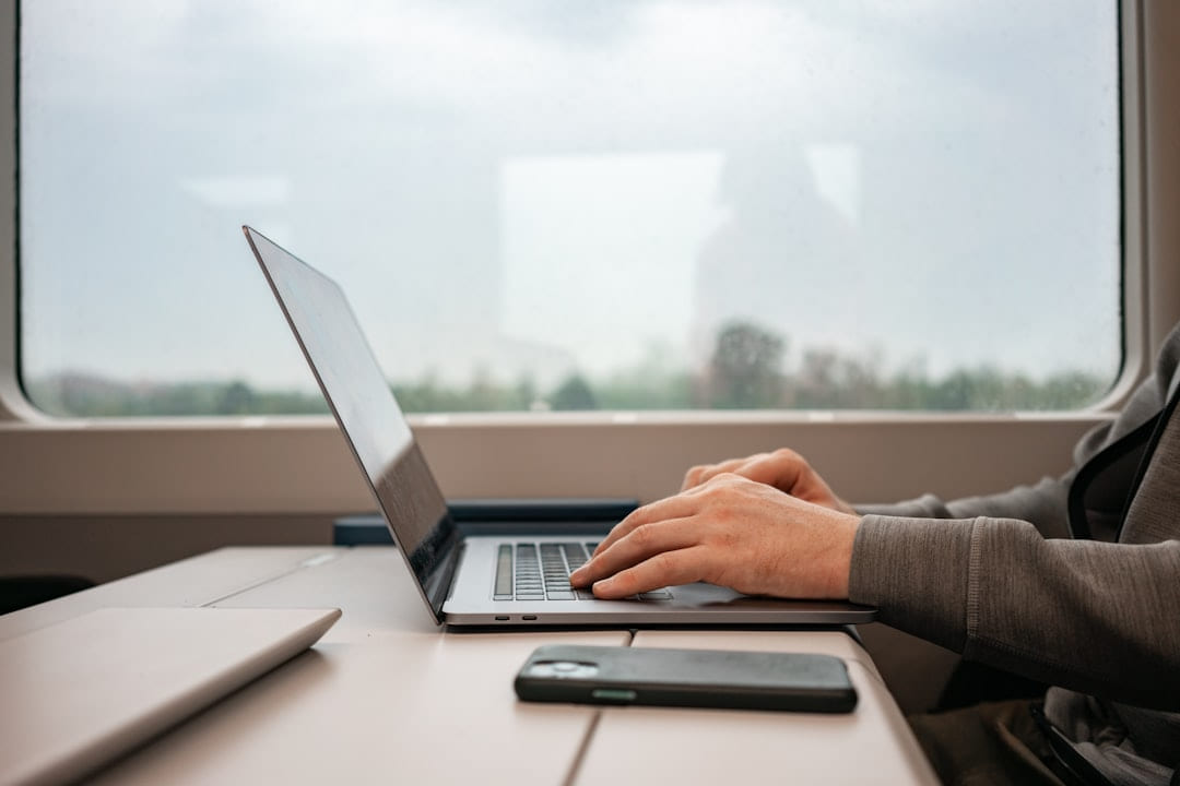 a man sitting at a desk using a laptop computer on The Anywhere Office