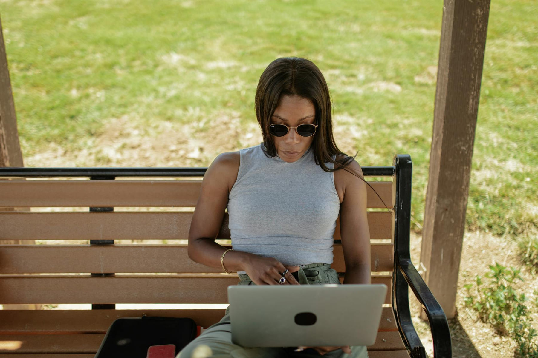 Businesswoman using laptop outside on a sunny day. Ideal for remote work themes. on The Anywhere Office
