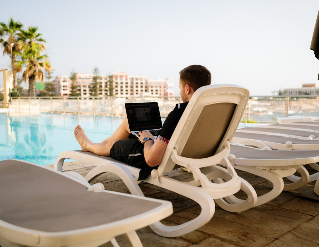 man on sun lounger using laptop on The Anywhere Office