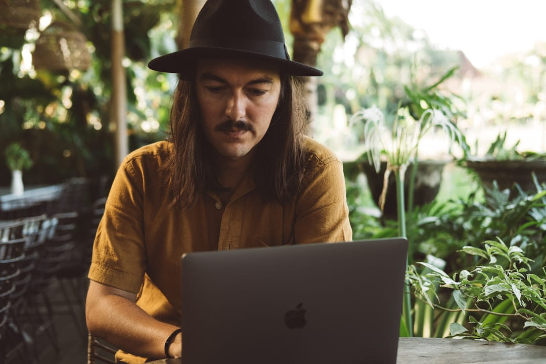 a man wearing a hat and using a laptop on The Anywhere Office