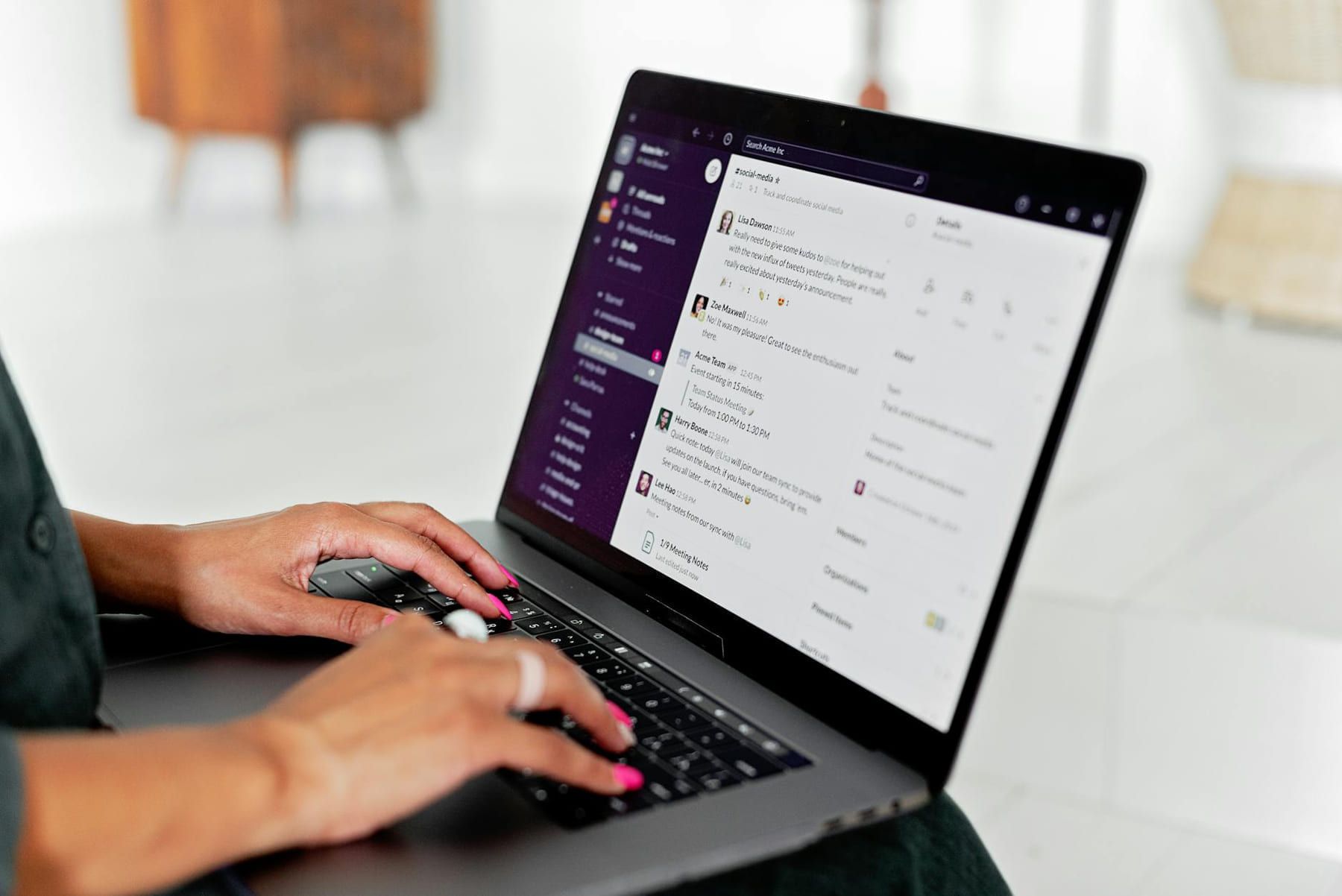 A woman types on a laptop using a messaging app in a modern office setting. on The Anywhere Office